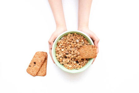 crispy muesli dry Breakfast in a bowl in hands isolated on white background selective focus, top view.の写真素材