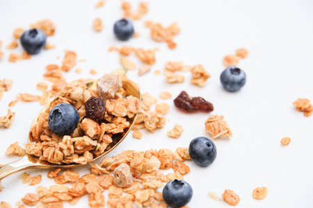 Crispy muesli and blueberry on a spoon Breakfast cereal isolated on white background, selective focus, top view.の写真素材
