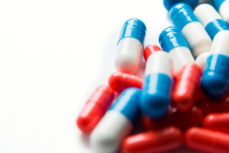 Multicolored capsules isolated on white background, copyspace for text, selective focus, top view. Pain meds, health, pills for the treatment of the concept of drug abuse.の写真素材