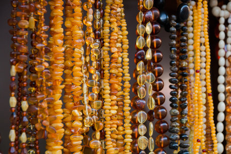 Amber background of beads and necklaces at the handicraft market. Jewelry design.の写真素材