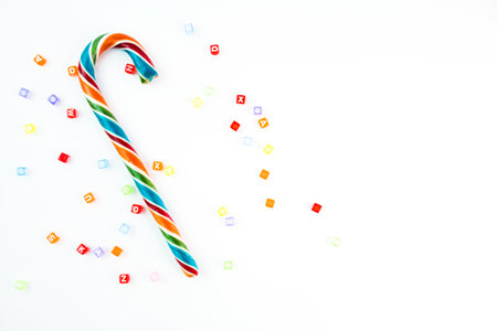Colorful festive Lollipop and small cube letters on white background selective focus top view.の写真素材