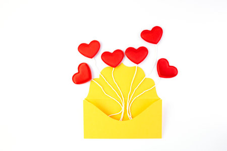 Valentine s day, red hearts on the rope from the yellow envelope isolated on white background.の写真素材