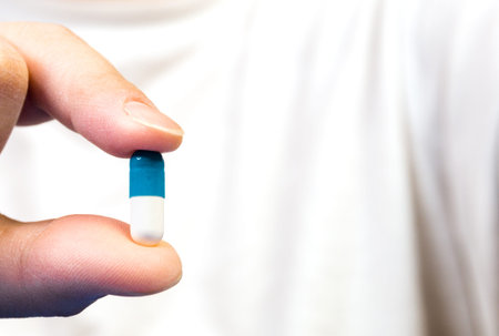 female hand holding a pill, diseases cold, flu.