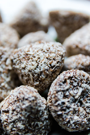 Chocolate candies in coconut shavings close-up, selective focus.