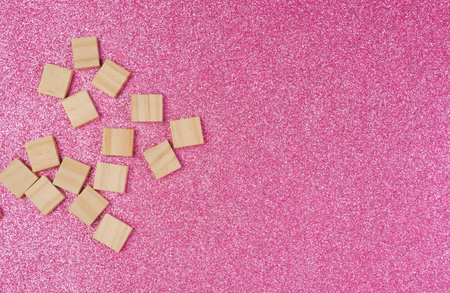 Empty pile of wooden letters on the surface of a pink background, selective focus.の写真素材