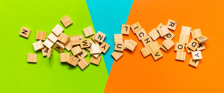 Pile of wooden letters on the surface of a multicolored paper background, selective focus.