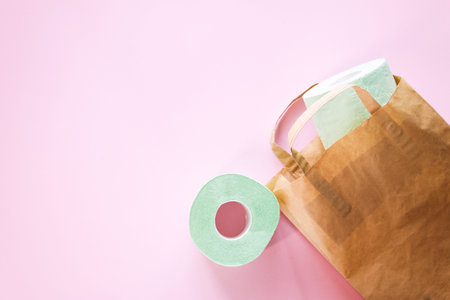 Toilet paper rolls and a craft bag on a pink background top view, selective focus.の写真素材