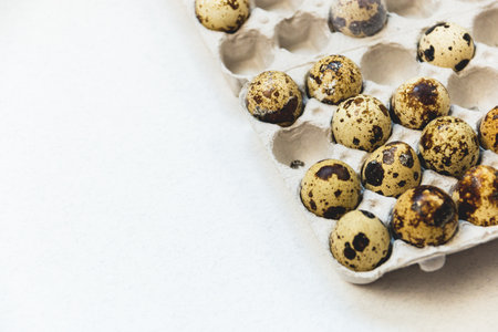 Quail eggs in cardboard packaging on white background. Top view.の写真素材