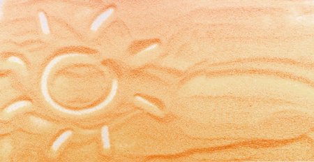 Background summer holidays, the sun painted on the sand. Concept of summer vacation on the beach.の写真素材