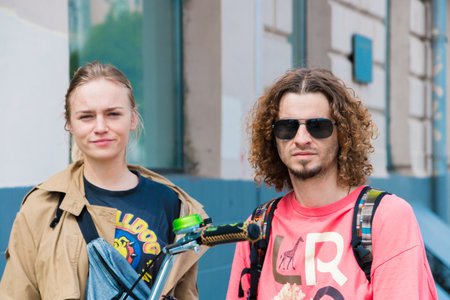 Unknown young cute couple passers-by pose for the camera in warm weather. Moscow, Russia, May 2020.のeditorial素材