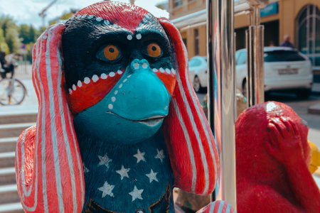 Street photo of a figure of a bright colored monkey holding a head of unusual color depicts various emotions. Moscow. Russia. June 2020.のeditorial素材