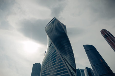 High modern glass tower of the Moscow city district for a business background against a cloudy dark...