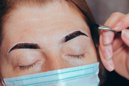 Beauty treatment. Correction and coloring of the eyebrows, shaping the eyebrows, removing hair with wax. Selective focus.の写真素材