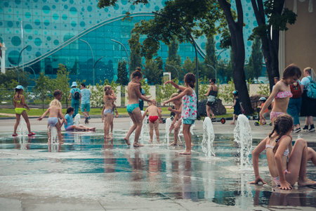Hot summer weather, unknown small children bathe in the city fountain in the park. Moscow, Russia, July 2020.のeditorial素材