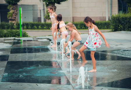 Hot summer weather, unknown small children bathe in the city fountain in the park. Moscow, Russia, July 2020.のeditorial素材