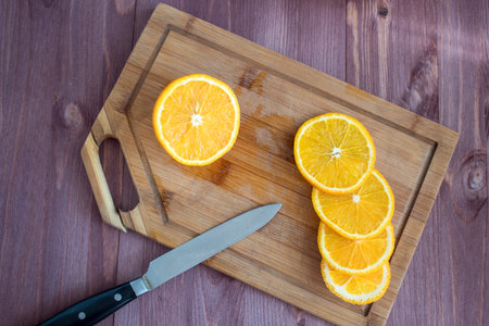 orange and knife on a wooden board. cut orangeの写真素材