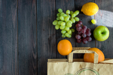 fruits in a paper bag. orange, lemon, apple, grapefruit, grapes. environmentally friendly. vegetarianism. view from aboveの写真素材