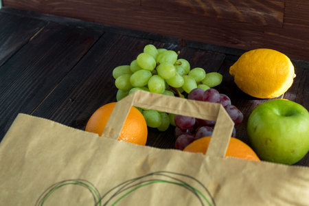 fruits in a paper bag. orange, lemon, apple, grapefruit, grapes. environmentally friendly. vegetarianismの写真素材