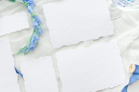 Blue wedding invitation mockup decorated with silk ribbon, crystals and bride wreath.