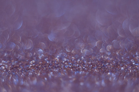 Abstract New Year purple bokeh background with shining defocus sparkles. Blurred glitters shimmering...