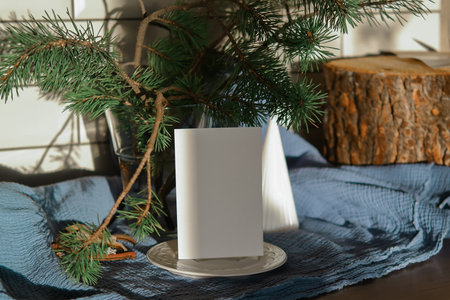 Christmas Ecological Mockup Card In Scandinavian Style. Christmas table setting with pine branches, candles, white plates and napkinsの写真素材