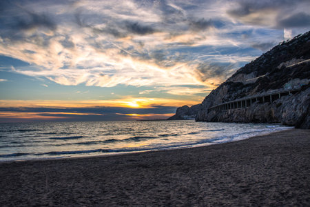 Amazing panoramic landscape of rocky shore photo. Sunrise sunset sky background with colorful clouds. Mediterranean sea. Beach concept photo. Bright seaside dusk. High quality picture for wallpaperの写真素材