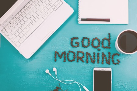 Creative flat lay photo of workspace desk with laptop, smartphone, coffee, coffee beans on blue backgroundの写真素材
