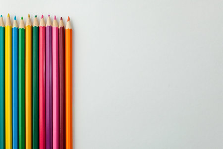 set of colored pencils on white background, place for text