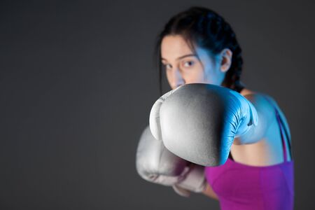 girl with the silver boxing gloves, black background with copy spaceの写真素材