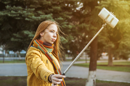 young girl doing selfie on nature on a sunny dayの写真素材