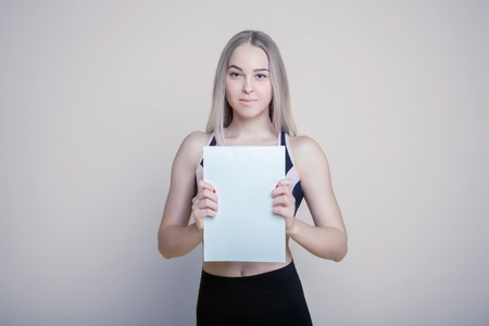 Pretty young woman holding empty blank board isolated on the backgroundの写真素材