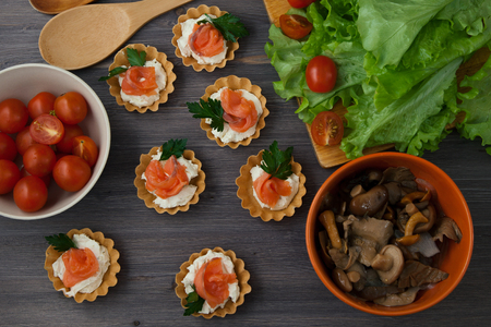 lettuce leaves , appetizer and cherry tomatoes on a dark wooden backgroundの写真素材
