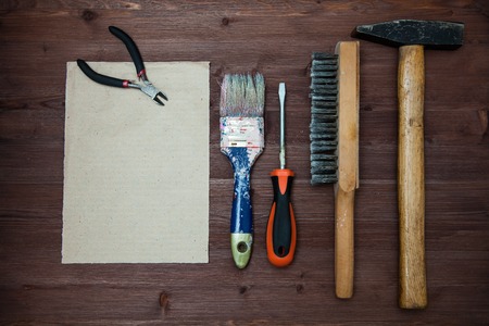 working tools spread out on a wooden background, brushes, screwdriver, brush, stapler. Concept of construction, wooden background, space for text. Top viewの写真素材
