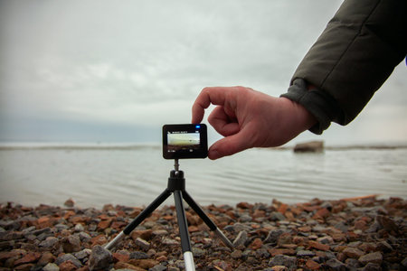 Male hand includes action camera, shoot marine look.
