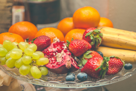 Fruits, tangerines, bananas, strawberries in a plate. Restaurant menu concept Backgroundの写真素材