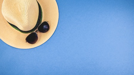 straw hat with sunglasses on a blue background Top view Copyspace Banner conceptの写真素材