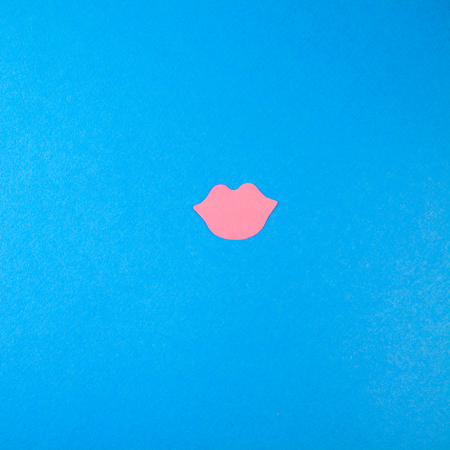 pink lips made of paper on a blue background. The concept for the world day of kisses Copy space Top view.の写真素材
