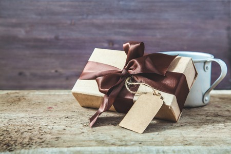 Father's Day. Gift box with a tag and coffee cup on a wooden background Copy space.の写真素材