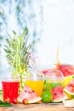 Bright Fresh healthy juices, fruit, pineapple, watermelon on the background of the sea. Summer, rest, healthy lifestyle Copyspaceの写真素材