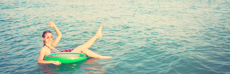 Beautiful Girl in inflatable ring having fun in the sea Summer vacationの写真素材