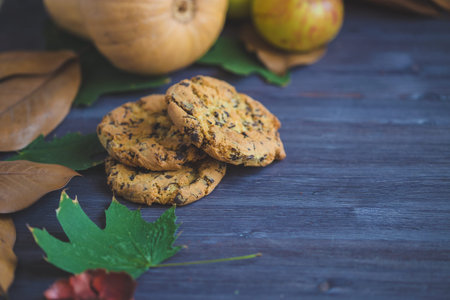 Autumn background. Cookies, Pumpkin Leaves Plaid Apples on a wooden background Copy space