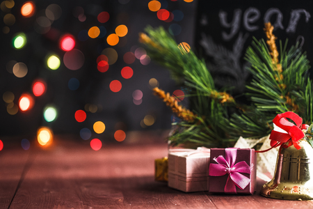 Christmas and New Year's concept. Gifts, lanterns, bell, bokeh on a wooden background Cの写真素材