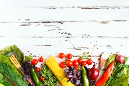 Cherry, tarragon, spaghetti, chili pepper, basil, spices Ingredients for cooking pasta. Food background on a white table Menu and restaurant concept Copy space Flat layの写真素材