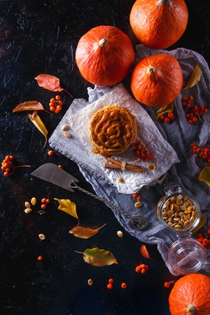 Autumn concept. Pumpkin pancakes with caramel topping, with pumpkins, leaves on a dark background.の写真素材