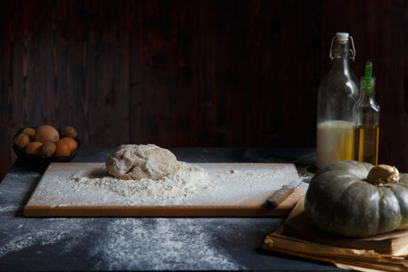 Baking Ingredients Eggs Pumpkin Butter Milk Nuts Flour On A Wooden Table Against A Dark Background...