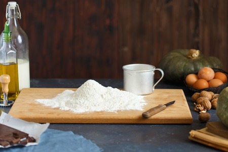 Baking Ingredients Eggs Pumpkin Butter Milk Nuts Flour On A Wooden Table Against A Dark Background Cope spaceの写真素材