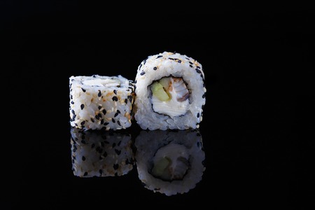 delicious sushi roll with fish on a black background with reflection Menu and restaurant concept Copy spaceの写真素材