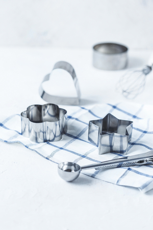 Cookie cutters, kitchen accessories on a white kitchen table Copy spaceの写真素材