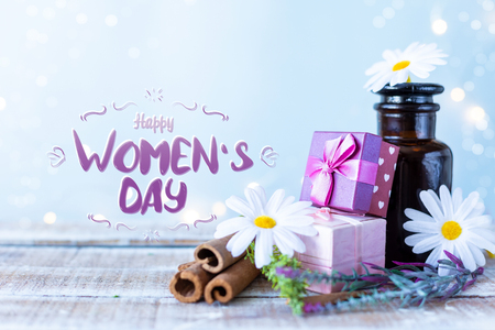 Boxes with gifts, a bouquet of flowers, cosmetic oil on a light blue background with the inscription Women's Day . Lettringの写真素材