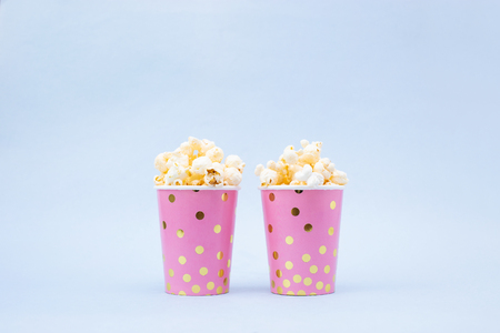 cup of tasty popcorn on a blue backgroundの写真素材